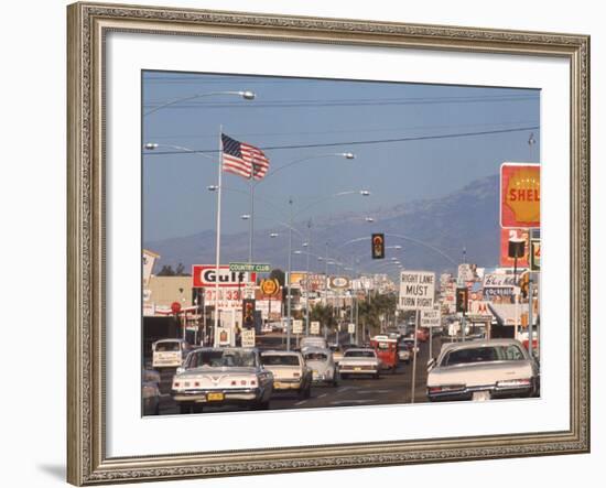 Cars Moving Along Congested Street, Littered with Signs, Billboards and Traffic Directives-Michael Rougier-Framed Photographic Print