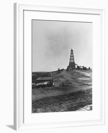 Century Oil Co. Sitting in Field Where Horses and People Mill About Tiny Lone House Sits in Fore.-null-Framed Photographic Print