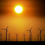 A Group of Wind Turbines are Silhouetted by the Setting Sun-Charlie Riedel-Photographic Print