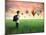 Child Carrying A Backpack Standing On A Green Meadow With Hot-Air Balloons In The Background-olly2-Mounted Art Print