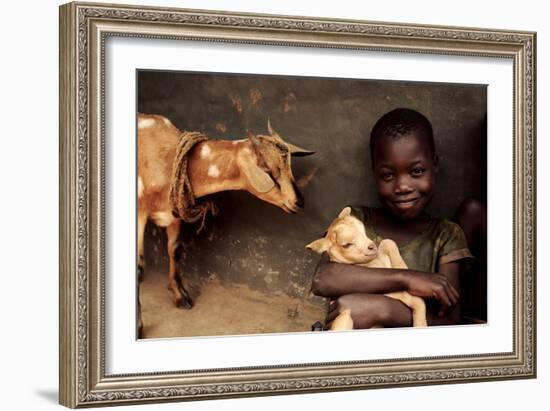 Child Holding a Kid-Mauro Fermariello-Framed Photographic Print