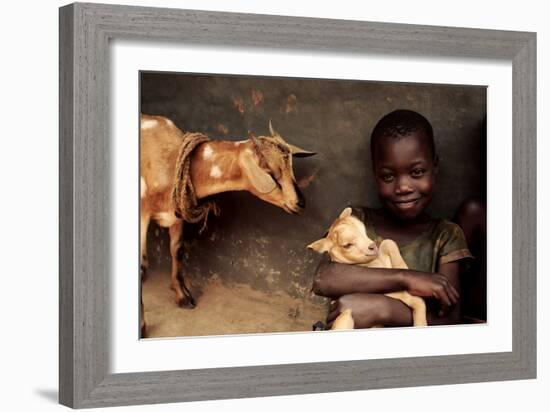 Child Holding a Kid-Mauro Fermariello-Framed Photographic Print