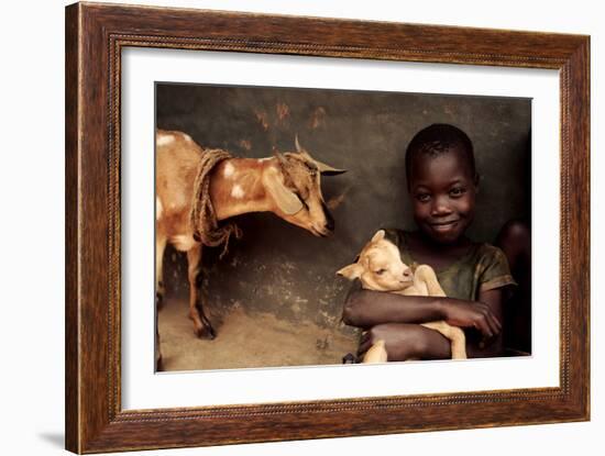 Child Holding a Kid-Mauro Fermariello-Framed Photographic Print