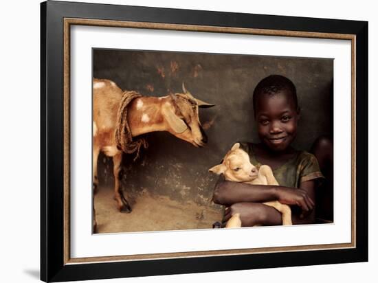 Child Holding a Kid-Mauro Fermariello-Framed Photographic Print