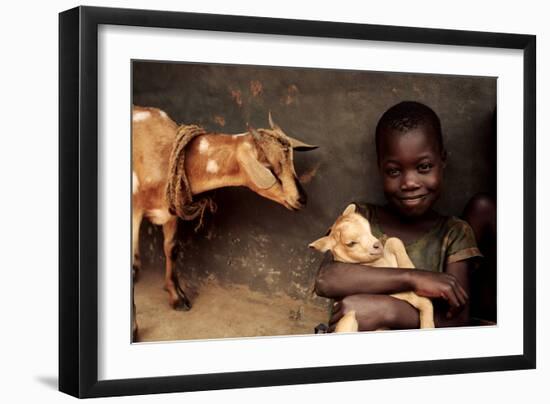 Child Holding a Kid-Mauro Fermariello-Framed Photographic Print