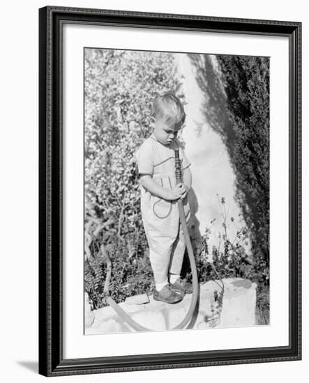 Child Pointing Hose at Face-null-Framed Photo