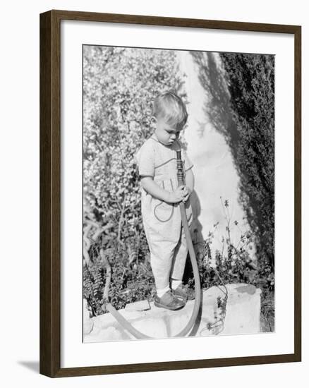 Child Pointing Hose at Face-null-Framed Photo