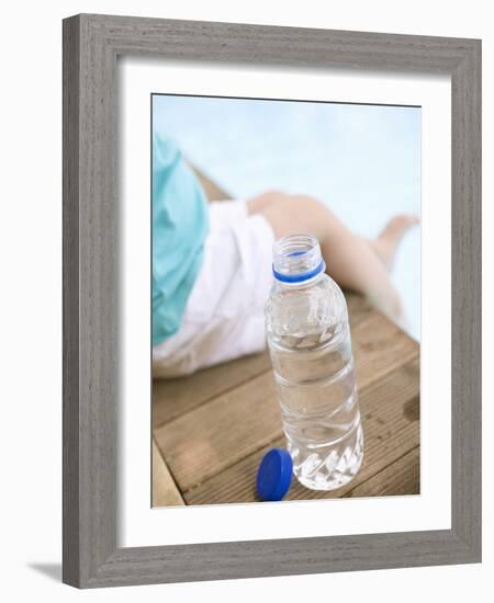 Child Sitting Beside Bottle of Water on Edge of Pool-null-Framed Photographic Print