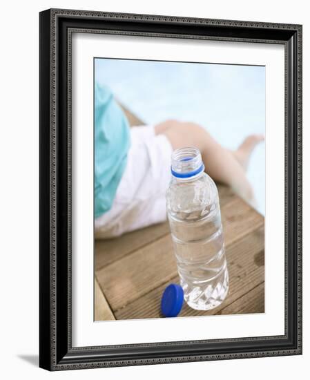 Child Sitting Beside Bottle of Water on Edge of Pool-null-Framed Photographic Print