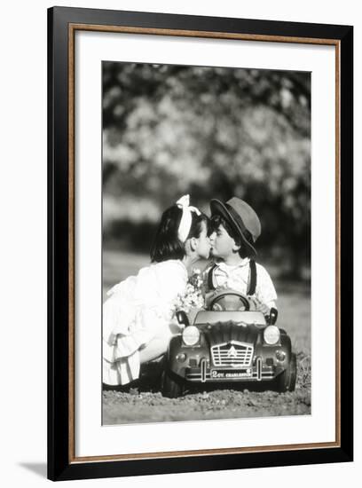 Children Kiss in Toy Car-null-Framed Photographic Print