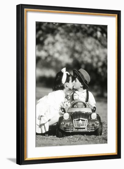 Children Kiss in Toy Car-null-Framed Photographic Print