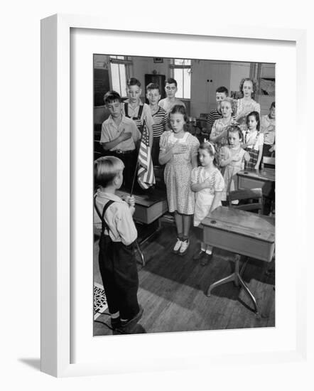 Children Reciting the Pledge of Allegiance as a Boy Holds the Us Flag in their Classroom-Bernard Hoffman-Framed Photographic Print