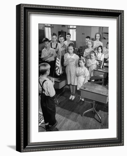 Children Reciting the Pledge of Allegiance as a Boy Holds the Us Flag in their Classroom-Bernard Hoffman-Framed Photographic Print
