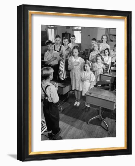 Children Reciting the Pledge of Allegiance as a Boy Holds the Us Flag in their Classroom-Bernard Hoffman-Framed Photographic Print