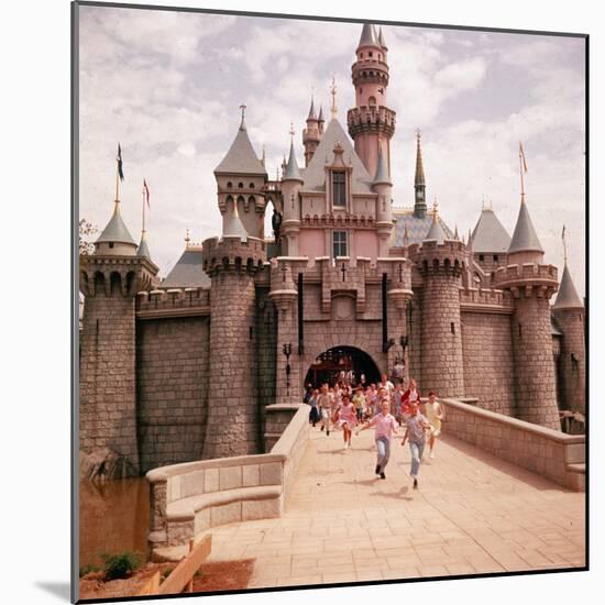 Children Running Through Gate of Sleeping Beauty's Castle at Walt Disney's Theme Park, Disneyland-Allan Grant-Mounted Photographic Print