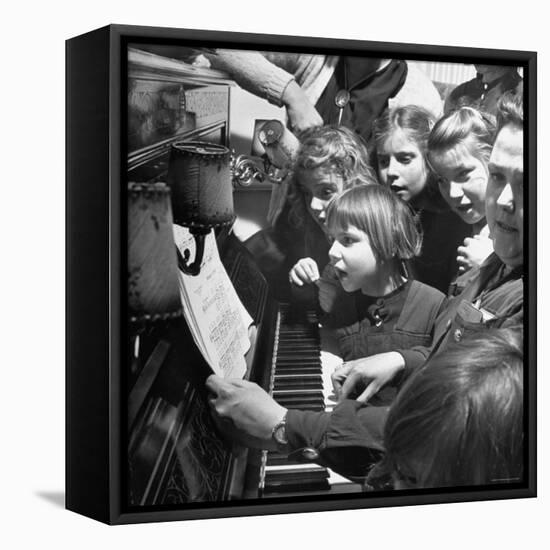 Children Singing Around the Piano at Orphanage-Tony Linck-Framed Premier Image Canvas