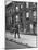 Children Watching a Policeman Walk His Beat in Front of Apartment Buildings-Ed Clark-Mounted Photographic Print