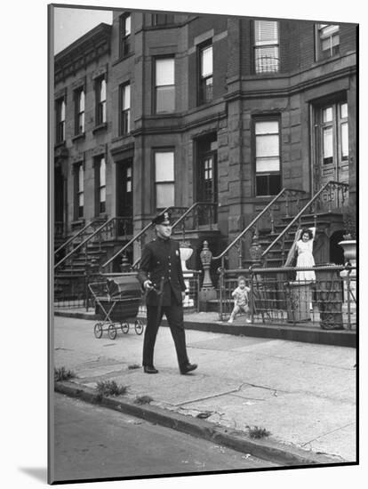 Children Watching a Policeman Walk His Beat in Front of Apartment Buildings-Ed Clark-Mounted Photographic Print