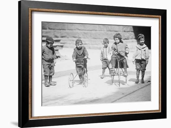 Children With Tricycles Playing In Manhattan Street-null-Framed Art Print