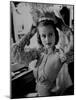 Chorus Girl Hope Chandler Securing Her Feathered Headdress as She Sits at Makeup Table-Peter Stackpole-Mounted Photographic Print