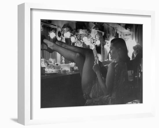 Chorus Girl-Singer Linda Lombard, Resting Her Legs after a Tough Night on Stage-George Silk-Framed Photographic Print