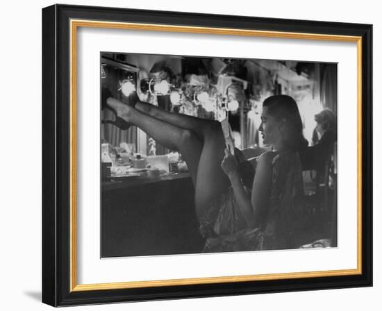 Chorus Girl-Singer Linda Lombard, Resting Her Legs after a Tough Night on Stage-George Silk-Framed Photographic Print