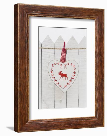 Christmas Ornament Hanging in Front of White Wooden Fence-Andrea Haase-Framed Photographic Print