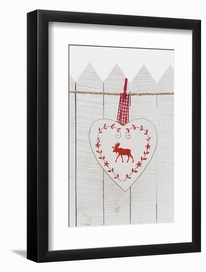 Christmas Ornament Hanging in Front of White Wooden Fence-Andrea Haase-Framed Photographic Print