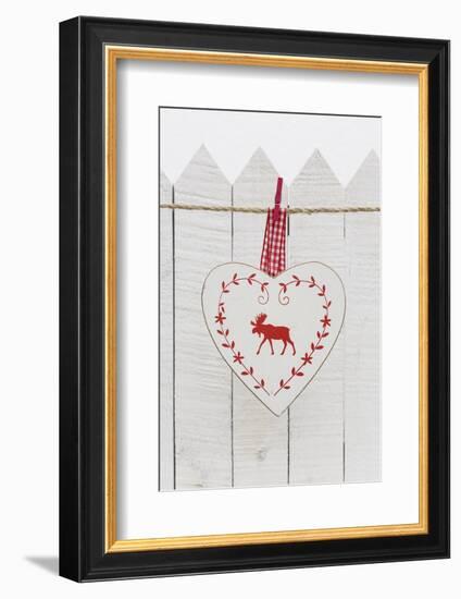 Christmas Ornament Hanging in Front of White Wooden Fence-Andrea Haase-Framed Photographic Print