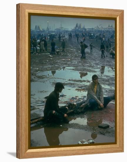 Chuck Morgan Sitting in the Mud and Water with a Friend, During Woodstock Music and Art Fair-John Dominis-Framed Premier Image Canvas