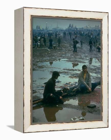 Chuck Morgan Sitting in the Mud and Water with a Friend, During Woodstock Music and Art Fair-John Dominis-Framed Premier Image Canvas