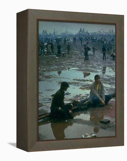 Chuck Morgan Sitting in the Mud and Water with a Friend, During Woodstock Music and Art Fair-John Dominis-Framed Premier Image Canvas