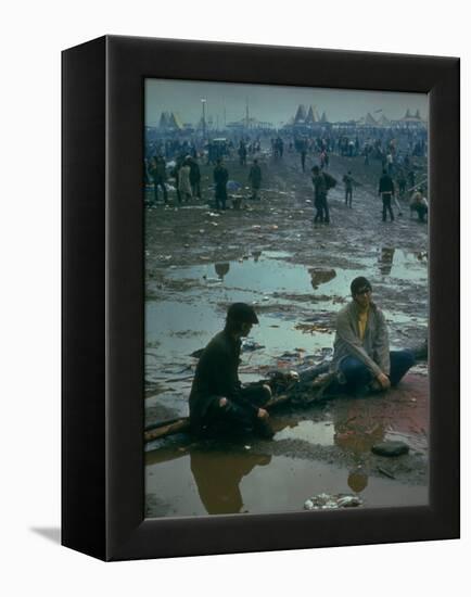 Chuck Morgan Sitting in the Mud and Water with a Friend, During Woodstock Music and Art Fair-John Dominis-Framed Premier Image Canvas