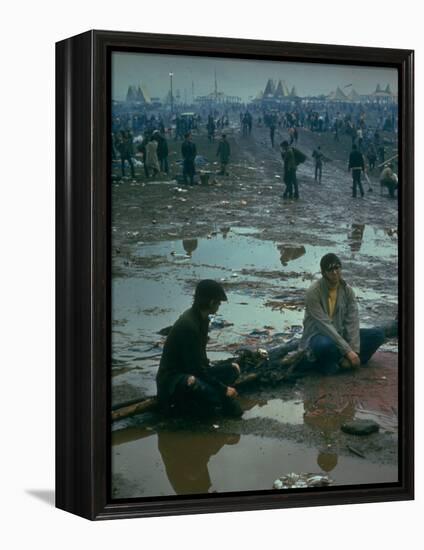 Chuck Morgan Sitting in the Mud and Water with a Friend, During Woodstock Music and Art Fair-John Dominis-Framed Premier Image Canvas