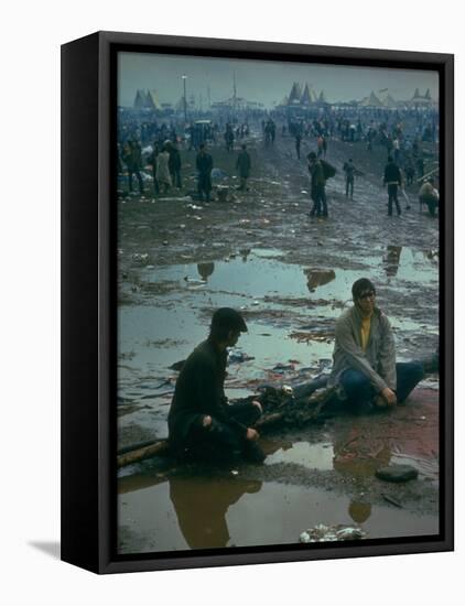 Chuck Morgan Sitting in the Mud and Water with a Friend, During Woodstock Music and Art Fair-John Dominis-Framed Premier Image Canvas