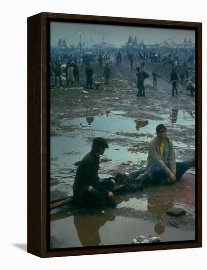 Chuck Morgan Sitting in the Mud and Water with a Friend, During Woodstock Music and Art Fair-John Dominis-Framed Premier Image Canvas