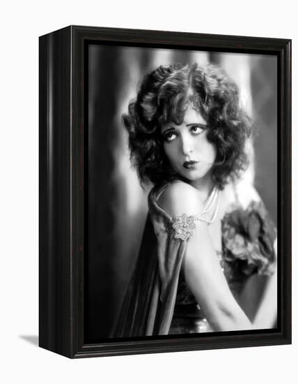 circa, 1929: Hollywood film star, Clara Bow (1905 - 1965) poses in a cape with jewelled clasp (b/w-null-Framed Stretched Canvas