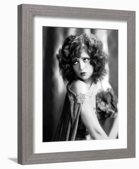 circa, 1929: Hollywood film star, Clara Bow (1905 - 1965) poses in a cape with jewelled clasp (b/w-null-Framed Photo