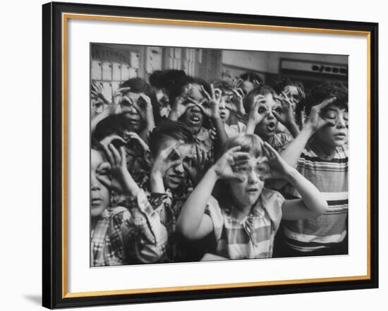 Classroom Full of Students Circling Fingers Around Eyes in Form of Glasses During Music Class-Francis Miller-Framed Photographic Print