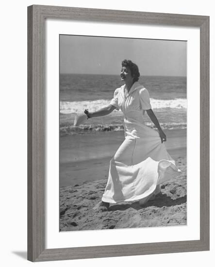 Claudette Colbert in Zippered, Terry Cloth Beach Robe, Sashaying Along Surf at Santa Monica Beach-Peter Stackpole-Framed Premium Photographic Print