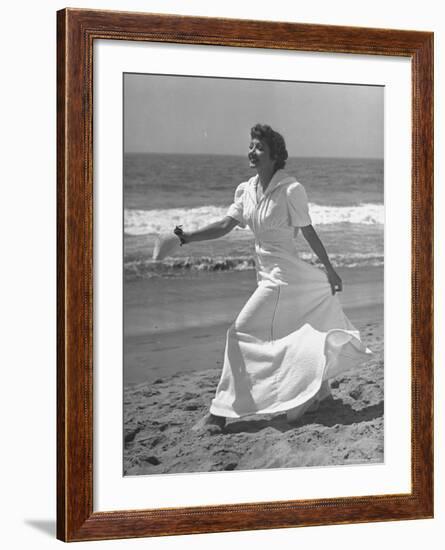 Claudette Colbert in Zippered, Terry Cloth Beach Robe, Sashaying Along Surf at Santa Monica Beach-Peter Stackpole-Framed Premium Photographic Print