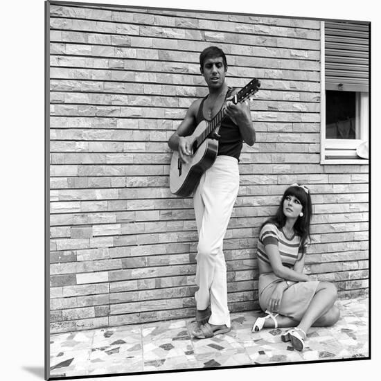 Claudia Mori Looking at Adriano Celentano Playing the Guitar-Marisa Rastellini-Mounted Photographic Print