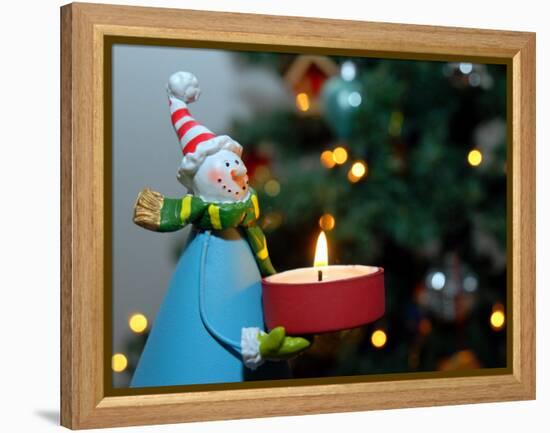 Close-Up of a Snow Man Candle in Front of a Tree with Christmas Lights-Winfred Evers-Framed Premier Image Canvas