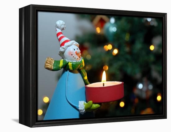 Close-Up of a Snow Man Candle in Front of a Tree with Christmas Lights-Winfred Evers-Framed Premier Image Canvas