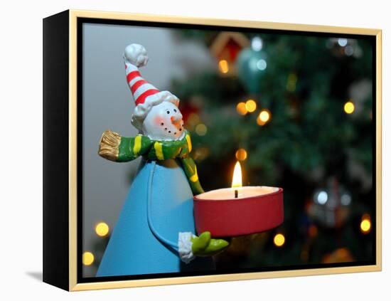 Close-Up of a Snow Man Candle in Front of a Tree with Christmas Lights-Winfred Evers-Framed Premier Image Canvas