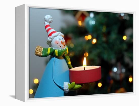 Close-Up of a Snow Man Candle in Front of a Tree with Christmas Lights-Winfred Evers-Framed Premier Image Canvas