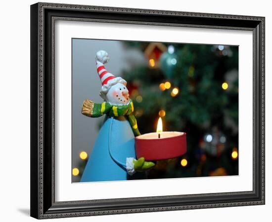 Close-Up of a Snow Man Candle in Front of a Tree with Christmas Lights-Winfred Evers-Framed Photographic Print