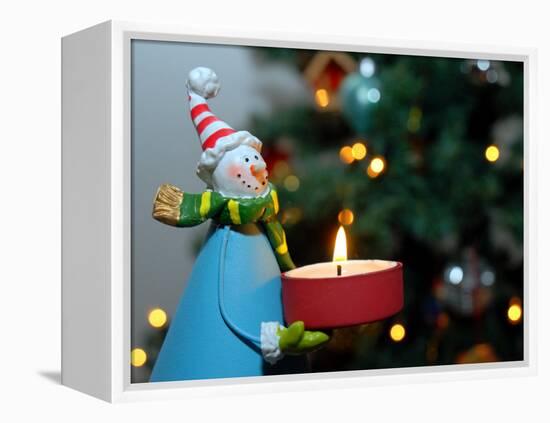 Close-Up of a Snow Man Candle in Front of a Tree with Christmas Lights-Winfred Evers-Framed Premier Image Canvas