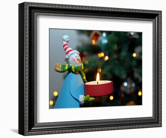 Close-Up of a Snow Man Candle in Front of a Tree with Christmas Lights-Winfred Evers-Framed Photographic Print