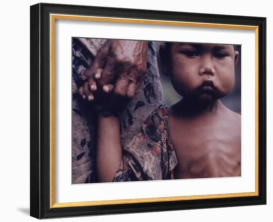 Close-Up of an Indonesian Child Holding on to the Hand of His Mother-Co Rentmeester-Framed Photographic Print